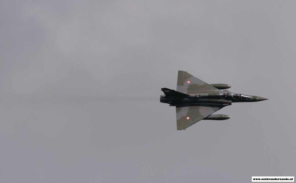 A French Mirage 2000 banks low over the range